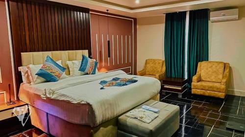 a bedroom with a bed and a desk and a chair at Tribu Hotels in Enugu