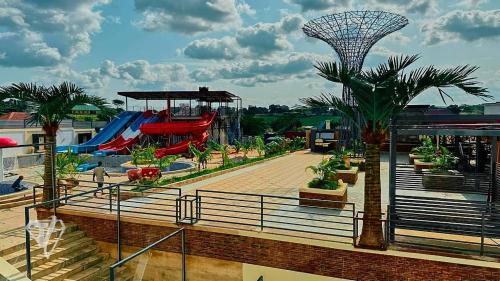 a resort with a playground with a slide and palm trees at Tribu Hotels in Enugu