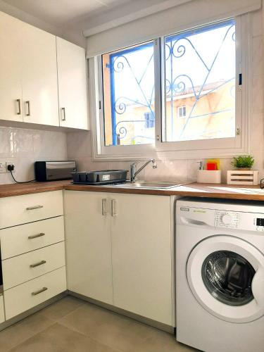 a kitchen with a washing machine and a sink at H&O Elegant Maisonette in Paradise Garden in Paphos