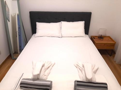 a bedroom with a white bed with a black headboard at H&O Elegant Maisonette in Paradise Garden in Paphos