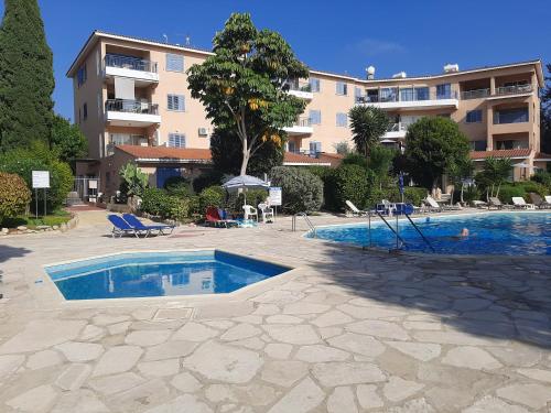 a swimming pool in front of a large building at H&O Elegant Maisonette in Paradise Garden in Paphos