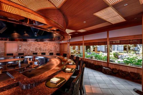 a restaurant with a bar with tables and chairs at The Westin Osaka in Osaka