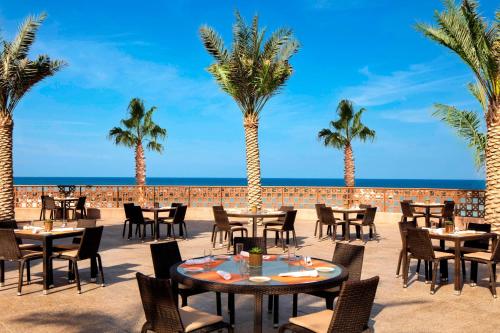 a restaurant on the beach with palm trees at Sheraton Sharjah Beach Resort and Spa in Sharjah