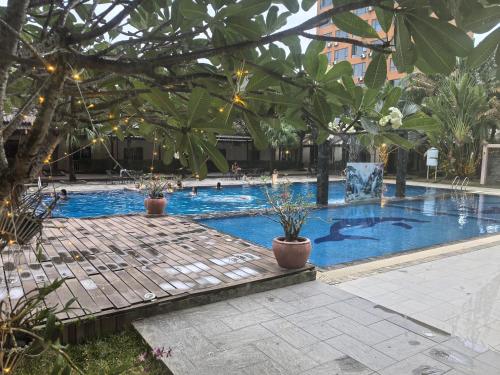 a large swimming pool with trees and plants at Twin Palms Resort in Sihanoukville