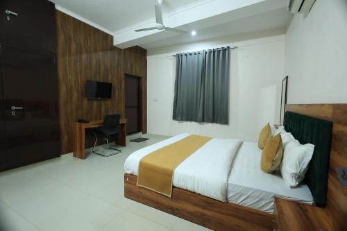 a bedroom with a bed and a desk in it at Hotel Classic Crown in Jaipur