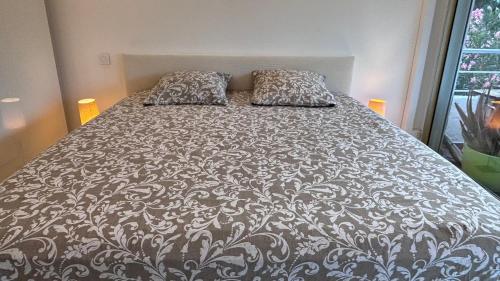 a bed with two pillows on it in a bedroom at JARDIN TERRASSE EDEN SAINT TROPEZ - Parking Pool AC 4P in Saint-Tropez