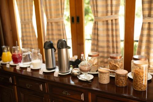 a wooden table with jars of food on top of it at Araucária Lodge - 800 metros do Capivari in Campos do Jordão