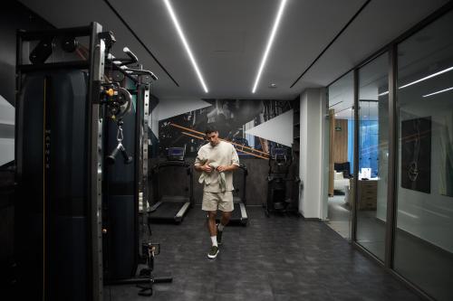 a man walking down a hallway with his cell phone at Myrion Beach Resort & Spa - Adults Only in Gerani Chanion