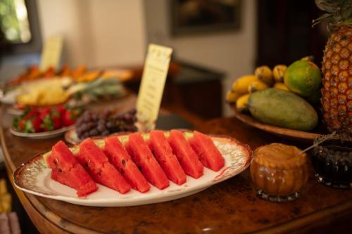 a table topped with plates of fruit on a table at Araucária Lodge - 800 metros do Capivari in Campos do Jordão