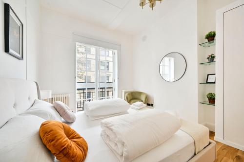 a white living room with a white couch and a window at Stunning 3 Bed Central London Apartment in London