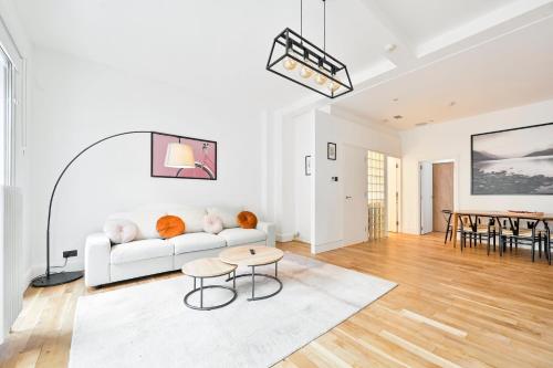 a white living room with a white couch and a table at Stunning 3 Bed Central London Apartment in London