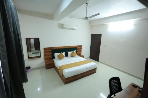 a bedroom with a bed and a chair in it at Hotel Classic Crown in Jaipur