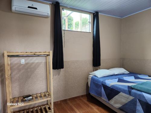 a bedroom with a bed and a window at KITNET'S DA DENI in Alto Paraíso de Goiás