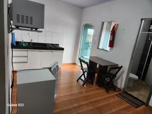 a small kitchen with a table and a stove at KITNET'S DA DENI in Alto Paraíso de Goiás