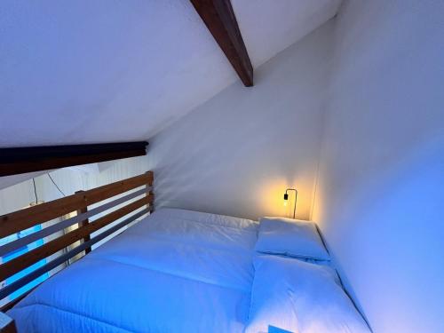 - une chambre blanche avec un lit éclairé dans l'établissement Studio chaleureux, à Cauterets