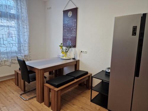 a table and chairs in a room with a refrigerator at Fewo Peter Erholungsort Bärenstein in Bärenstein