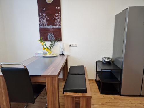 a dining room table with a chair and a refrigerator at Fewo Peter Erholungsort Bärenstein in Bärenstein