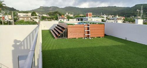 a roof garden with green grass on a building at Resort House Ricca in Nanjo