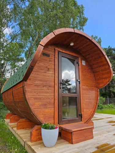 a wooden hobbit house with a glass door on a deck at NorGlamp Glamping in Hjelmeland