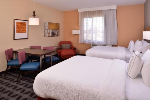 a hotel room with two beds and a table at TownePlace Suites by Marriott St. Louis Chesterfield in Chesterfield