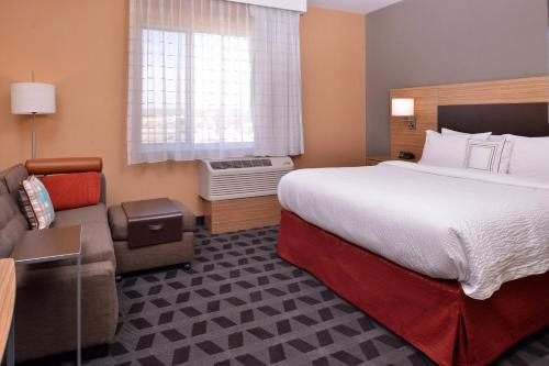 a hotel room with a large bed and a couch at TownePlace Suites by Marriott St. Louis Chesterfield in Chesterfield