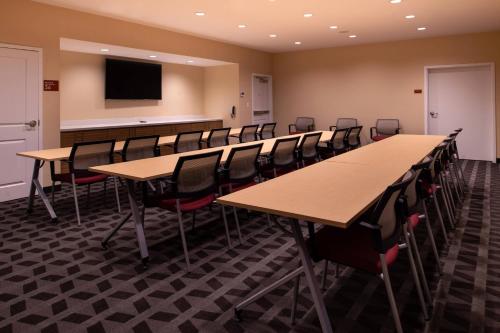 a conference room with tables and chairs and a tv at TownePlace Suites by Marriott St. Louis Chesterfield in Chesterfield