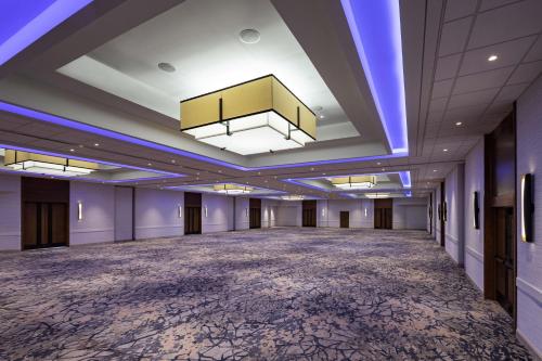 an empty ballroom with a large room with purple ceilings at Sheraton Charlotte Airport in Charlotte