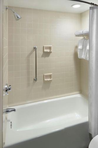 a bathroom with a bath tub with a shower at Sheraton Charlotte Airport in Charlotte