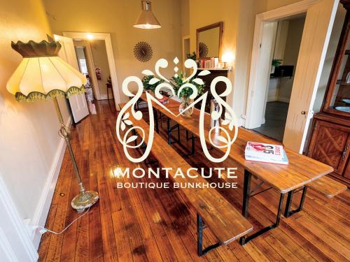 a room with a table and a lamp on a wooden floor at Montacute Boutique Bunkhouse in Hobart
