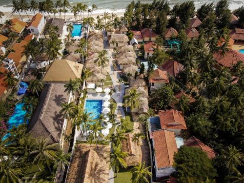 an aerial view of a resort with palm trees and the ocean at Coco Cottage Beachfront Resort in Mui Ne