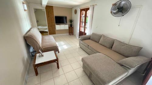 a living room with a couch and a chair at LES GITES DE LA RESERVE in Bouillante