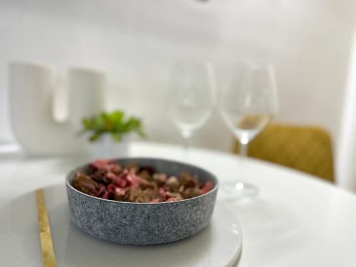 a bowl of food on a table with wine glasses at Ground Floor Apt with a Pool and Terrace in Pesnica pri Mariboru