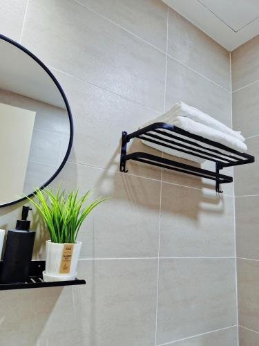a bathroom with a mirror and white towels on a shelf at Luxury Accommodation Trio Bukit Tinggi in Klang