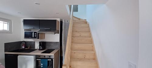 a stairway leading up to a kitchen with a stair case at Au cœur des 3 vallées in Sainte-Hélène-du-Lac