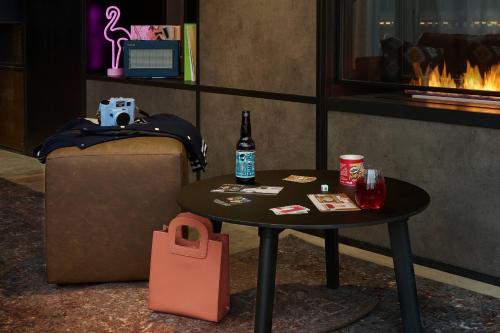 a table with a bottle of beer and a bag at Moxy Southampton in Southampton