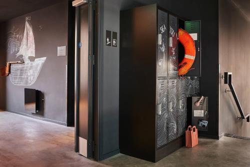 an elevator in a room with an orange object on the wall at Moxy Southampton in Southampton