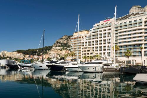 a group of boats docked in a marina in front of a building at Riviera Marriott Hotel La Porte De Monaco in Cap d'Ail