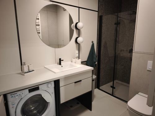 a bathroom with a washing machine and a sink at W centrum NOWY Kameralny Apartamenta, Duży Parking, FV, Luksusowo wyposażony, PlayStation 5, Balkon, Klimatyzacja, Taras, Winda, Wyposażona kuchnia in Starogard Gdański