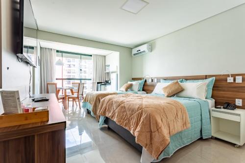 a bedroom with a large bed and a table at Flat - Conforto em ótima localização - Hotel Garvey in Brasilia
