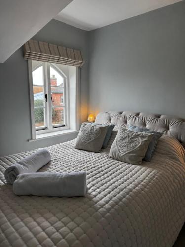 a large bed in a bedroom with a window at Cosy 2 bed cottage in beautiful Orford in Orford