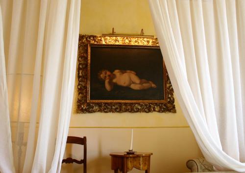 a painting of a woman laying on the wall next to curtains at Tenuta Del Gallo in Amelia