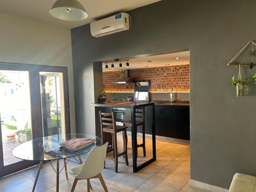 a kitchen and dining room with a glass table at The amphitheater house in Villa María