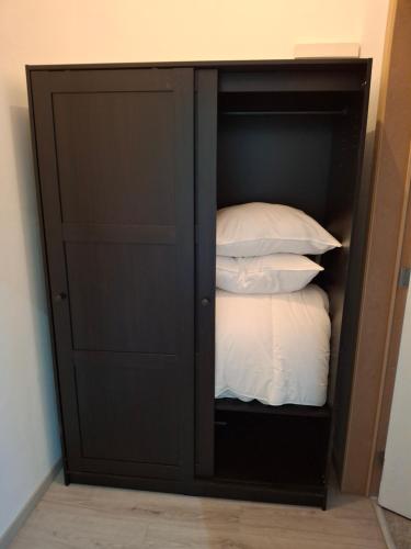 a black cabinet with white pillows in it at La Vie en Rose in Verviers