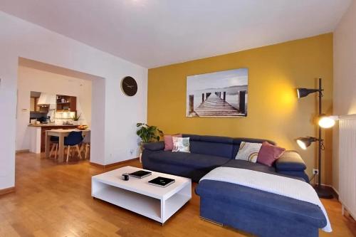 a living room with a blue couch and a table at Le Spacieux - centre-ville - 4 chambres - 8 pers in Sarreguemines