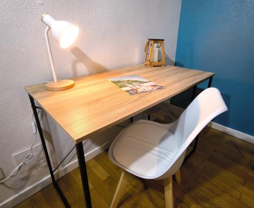 a wooden desk with a lamp and a white chair at Le Spacieux - centre-ville - 4 chambres - 8 pers in Sarreguemines