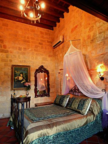 a bedroom with a bed with a mosquito net at S.Nikolis' Historic Boutique Hotel in Rhodes Town