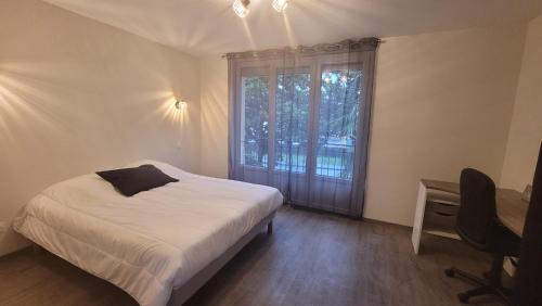une chambre avec un lit, une fenêtre et un bureau dans l'établissement BEL appartement T5 NEUF avec 4 chambres, à Tarbes