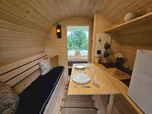 a small room with a table in a wooden cabin at NorGlamp Glamping in Hjelmeland