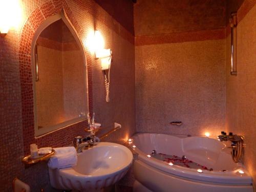 a bathroom with a sink and a tub and a toilet at S.Nikolis' Historic Boutique Hotel in Rhodes Town