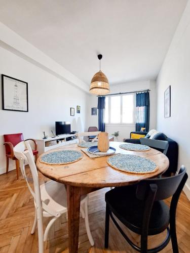une salle à manger et un salon avec une table et des chaises dans l'établissement Le Charme - APPARTEMENT CENTRE VILLE, PROCHE DE LA PLAGE ET DU MARCHÉ, à Royan